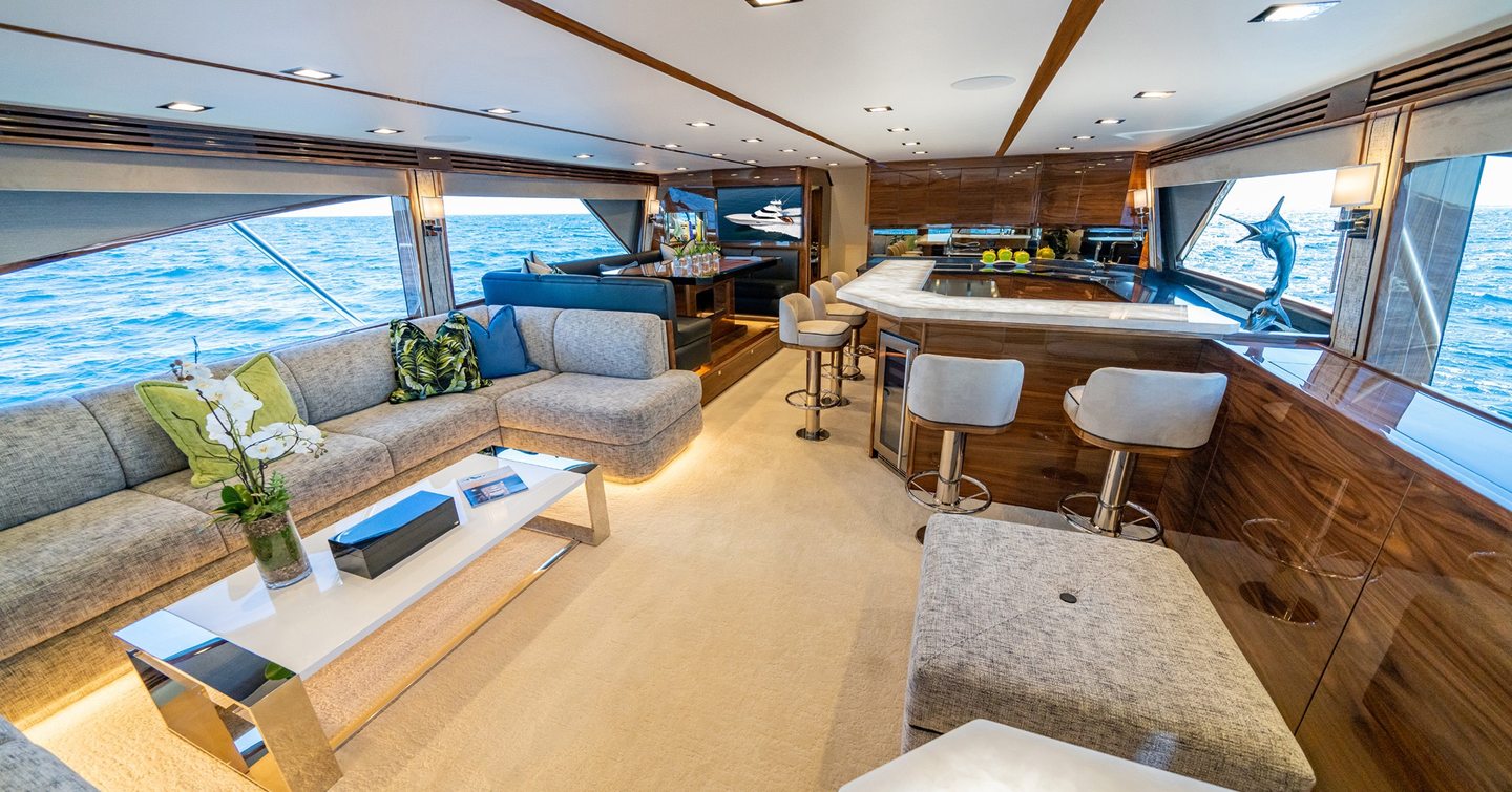 Viking 90C sportfisher yacht main saloon with l-shaped bar area and grey sofas 