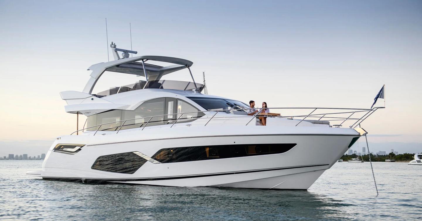 Sunseeker Manhattan 68 motor yacht at anchor with couple on foredeck