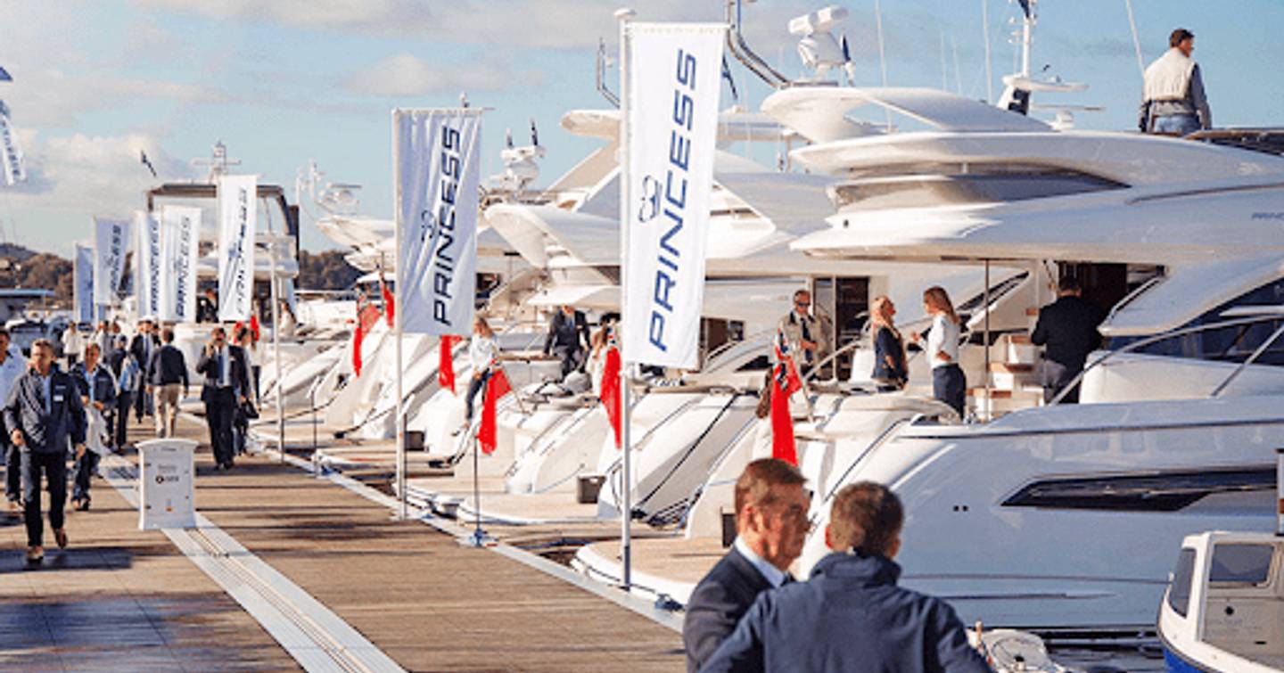 Line of Princess yachts berthed along dock at a boat show.