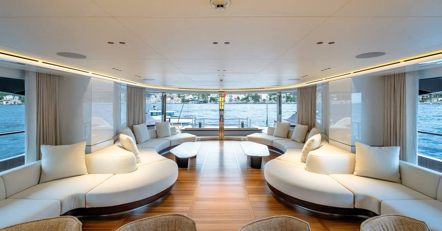 Superyacht Contigo's interior with curved sofa and large windows