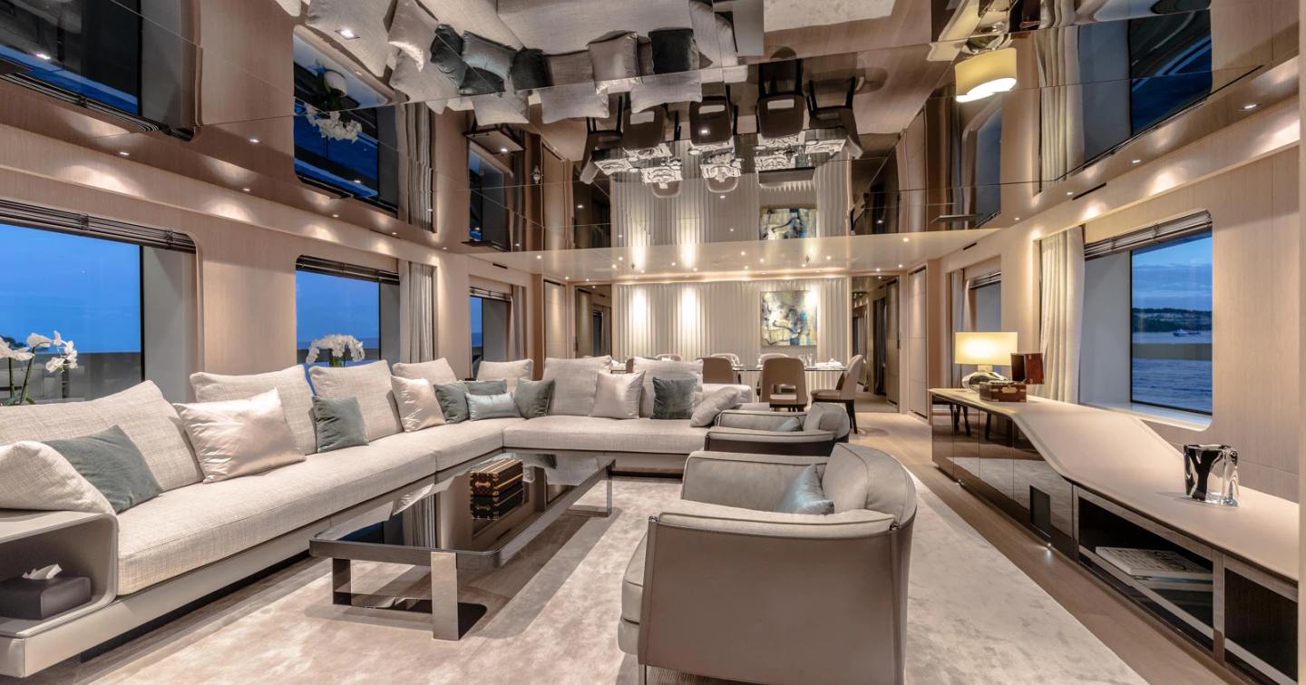 Superyacht Kinda main saloon with L-shaped sofa and mirror ceiling