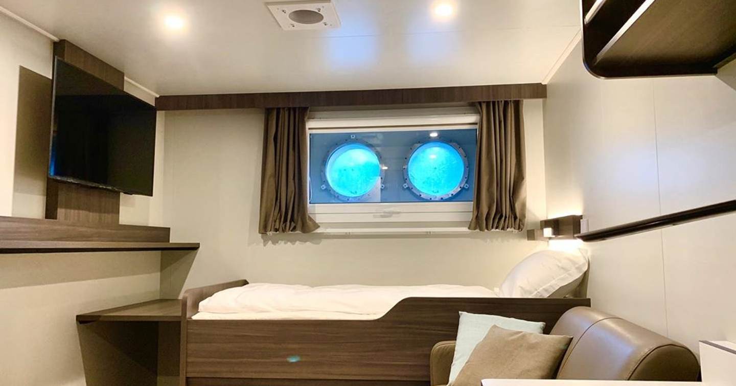 REV Ocean's bedroom with circular windows and mounted TV