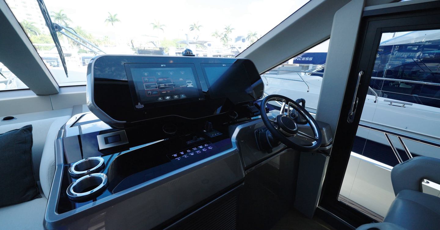 Lower helm station aboard the Galeon 620 Fly with twin multifunction displays and side-deck access door.