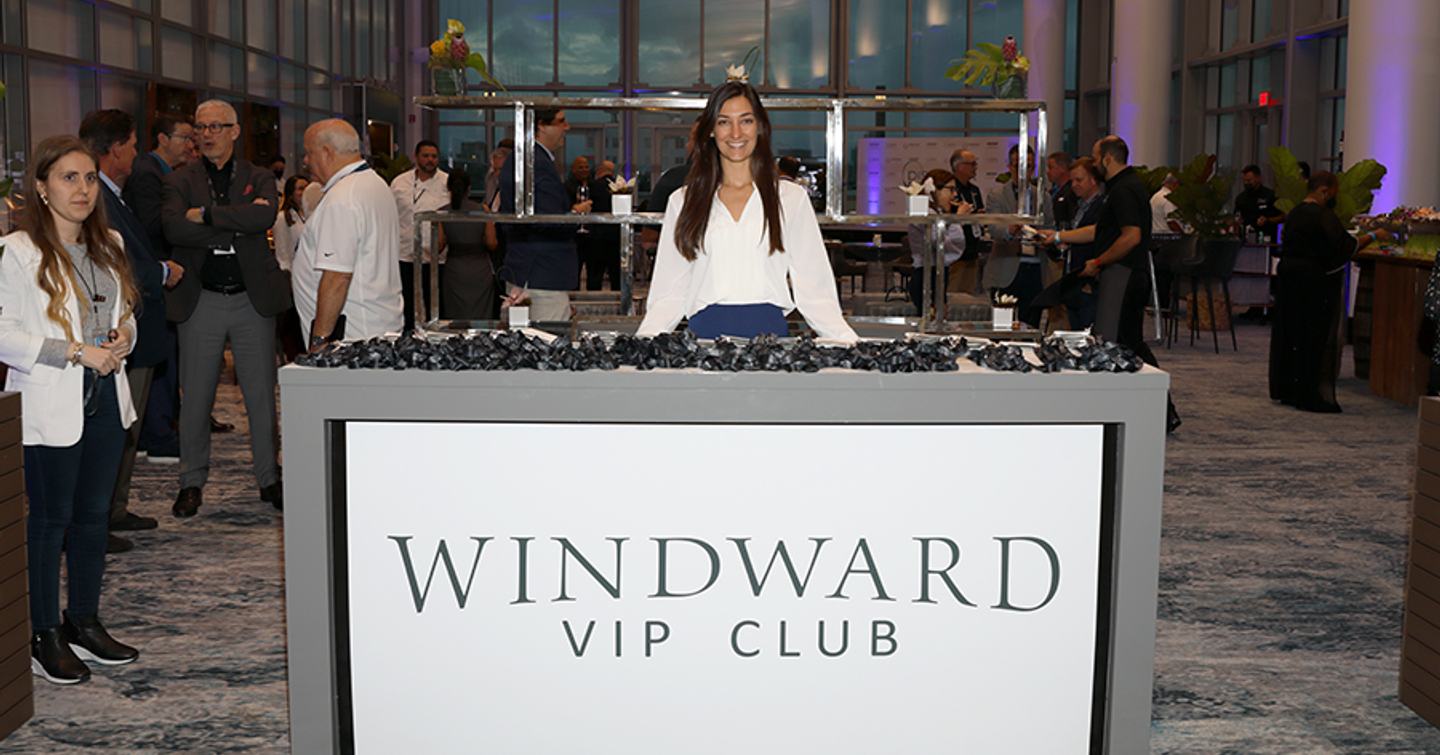 Windward VIP Experience at Miami International Boat Show. Female hostess posing behind reception desk.