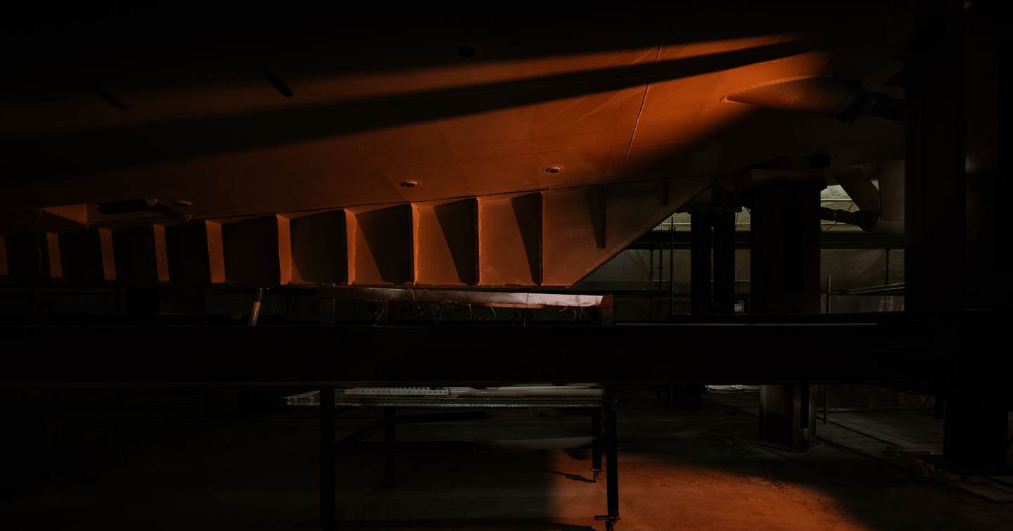 Hull of Sirena 42M superyacht under construction in dim red lighting