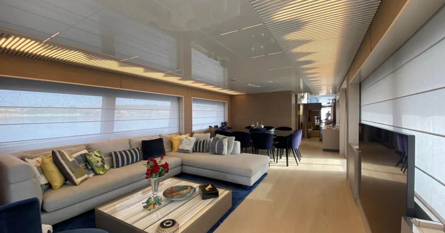Motor Yacht Sunrise main salon with L-shaped sofa and dining area 