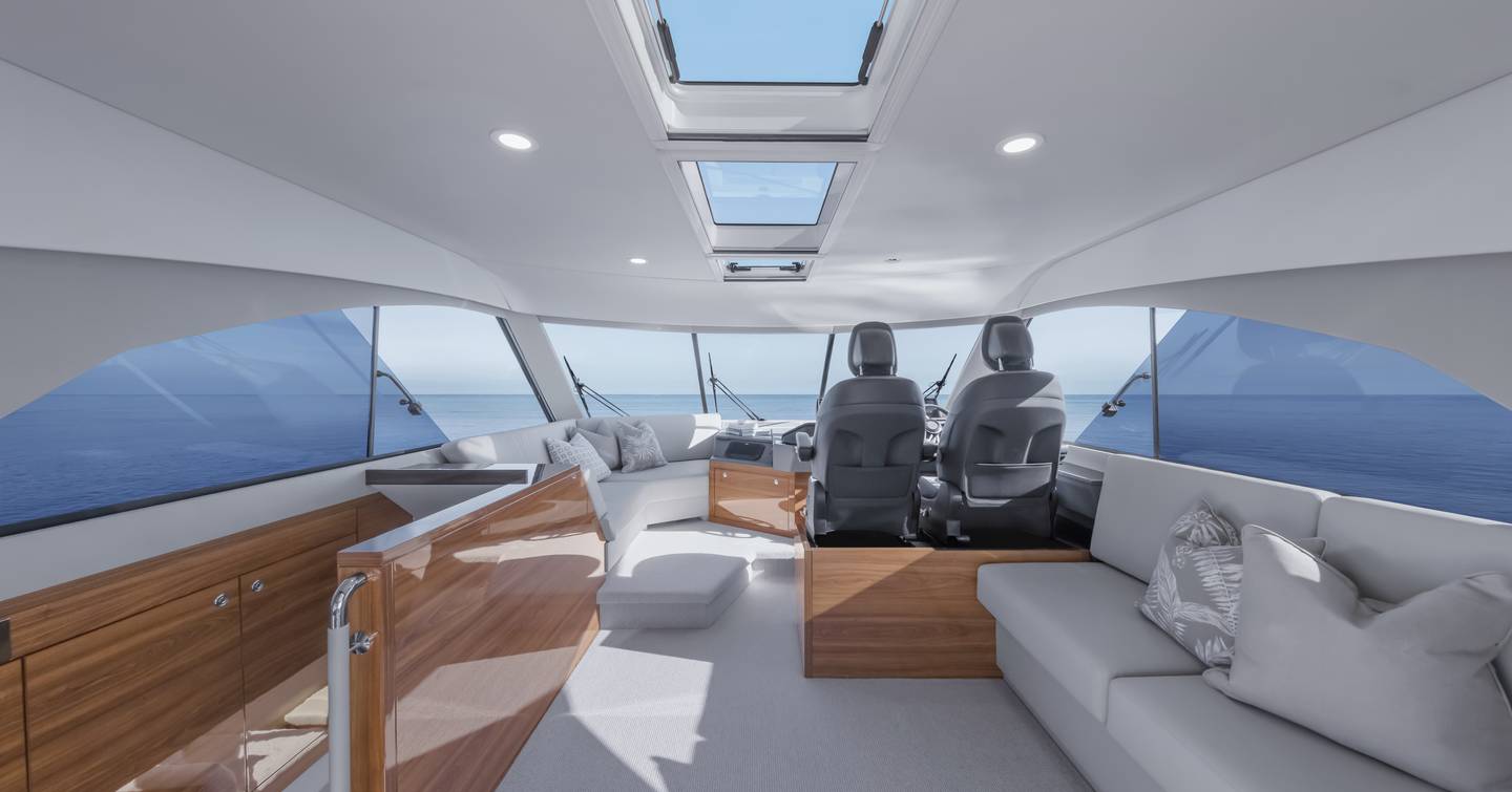 Maritimo M50 enclosed flybridge helm area with twin seats, sofa seating and panoramic glazing