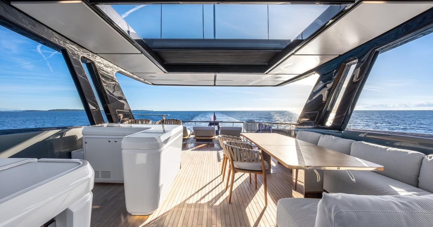 Motor Yacht Together flybridge with L-shaped grey sofa and integrated galley