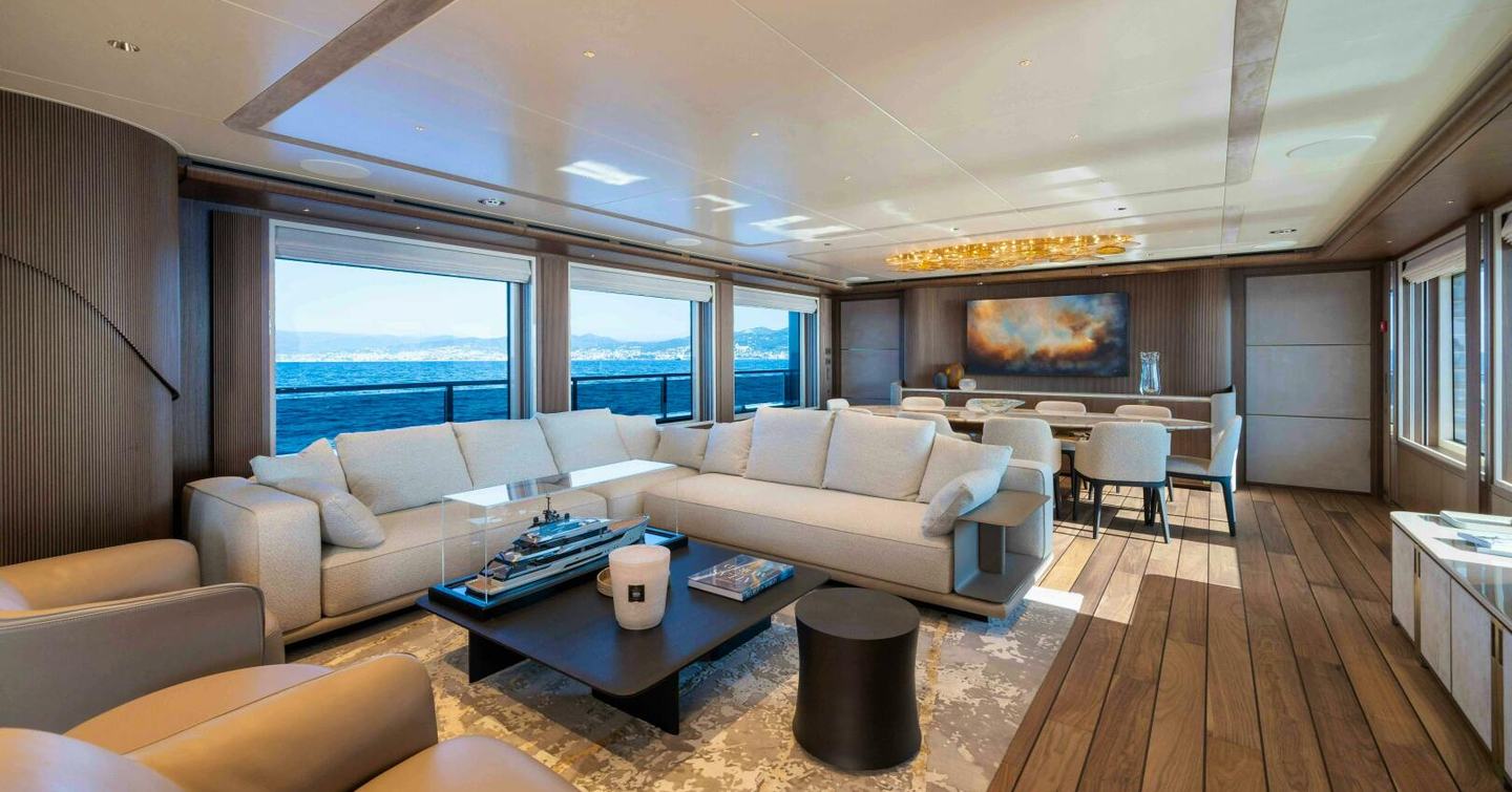 Superyacht Serenissima I main saloon with L-shaped sofa and dining area