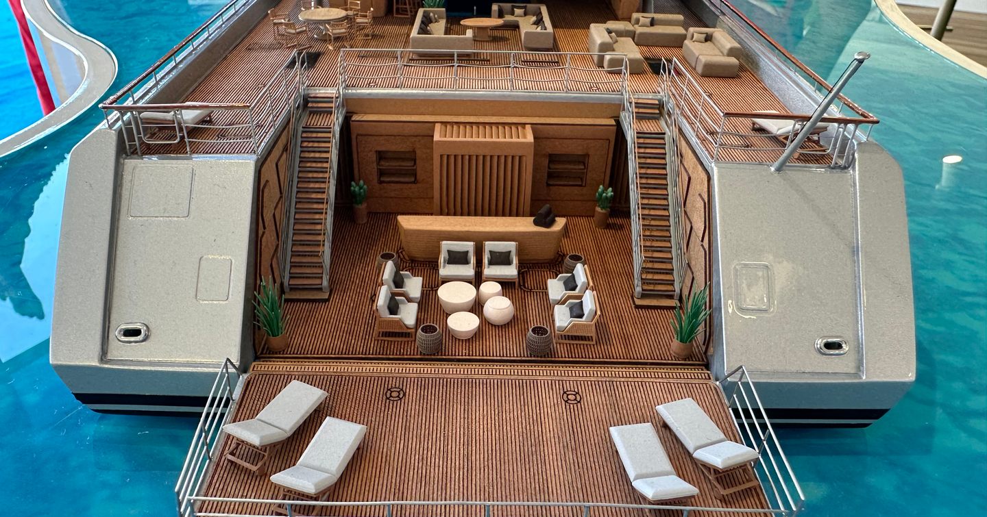 Aft view of a scale model of superyacht DRAGONFLY, beach club with sun loungers and exterior lounge area