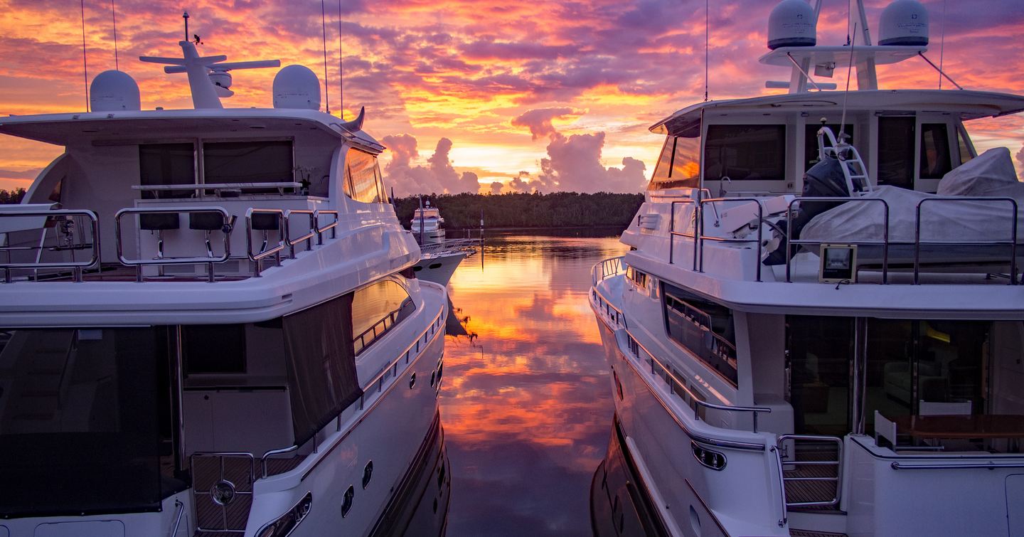 Two motor yachts berthed at Sanctuary Cove, Australia, at dusk.