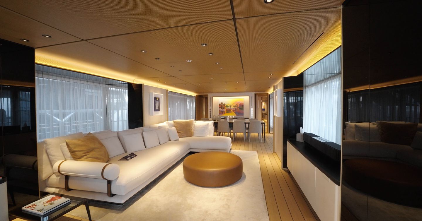 Custom Line Navetta 38 main saloon with L-shaped sofa, light interior finish and large side windows