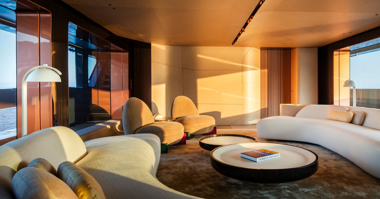 Rossinavi Superyacht Heed main salon with curved seating and warm lighting