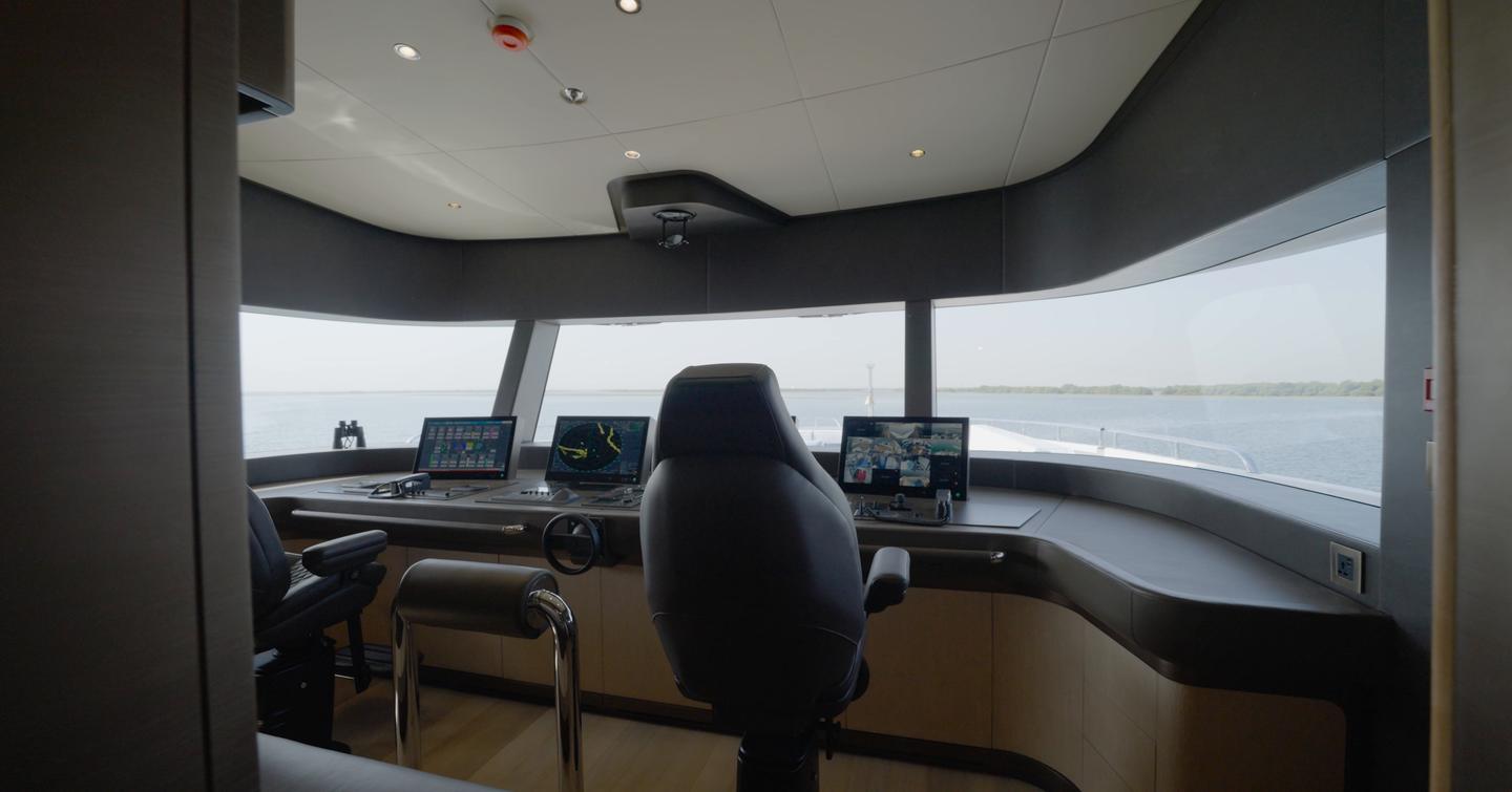 Wheelhouse aboard the Gulf Craft Majesty 145 with wide bridge windows, navigation displays and twin helm seats