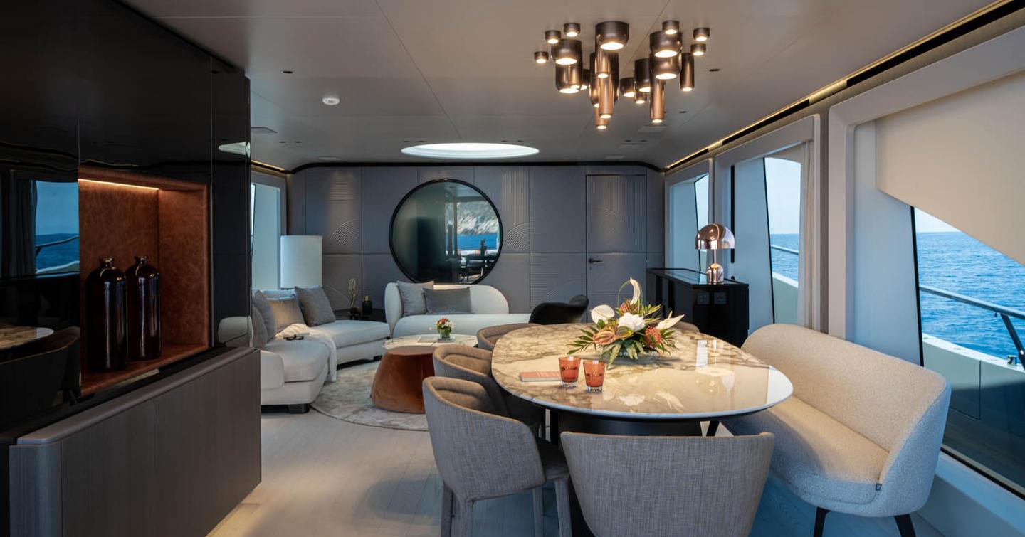 Mangusta 104 REV motor yacht main saloon with oval marbled dining table 