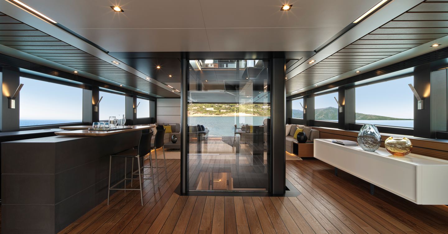 Wally wallywhy200 motor yacht main saloon with glass encased stairway and black bar area