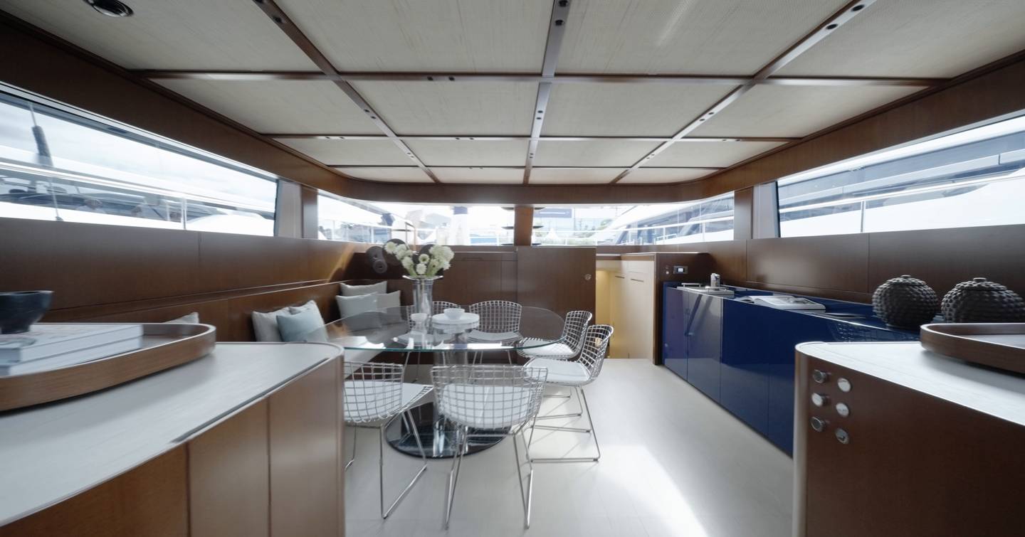 Dining area aboard the Sanlorenzo SHE with blue cabinetry and wraparound windows