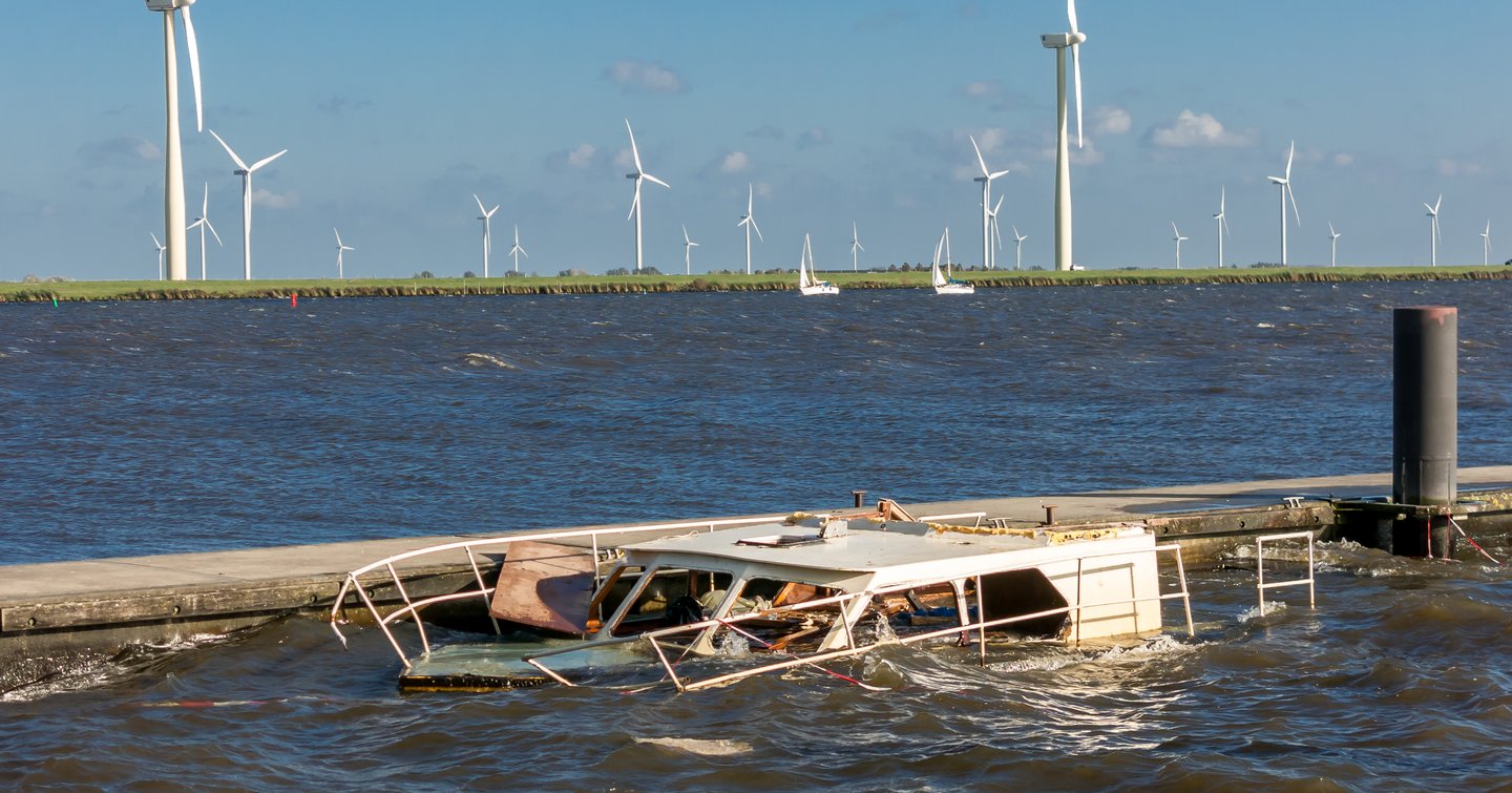 motor yacht sinking wind farm in distance