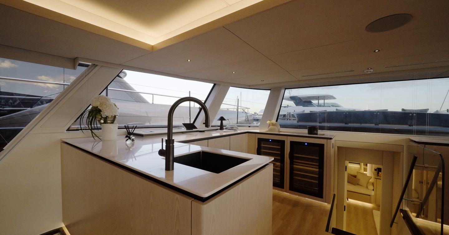 Sunreef Ultima 88 saloon bar galley with sink, wine fridges and forward glazing