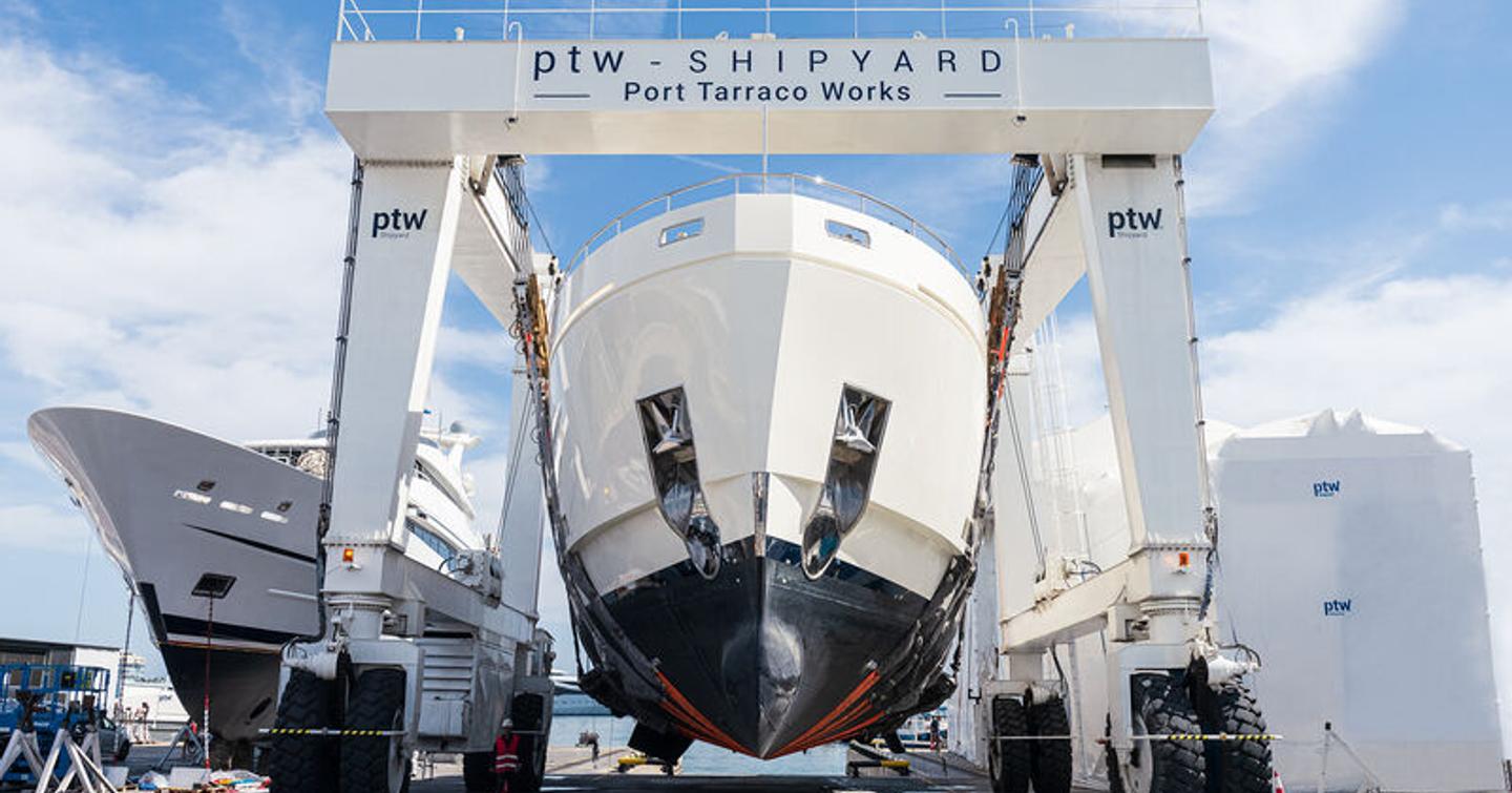 Overview of a crane at ptw Shipyard in Spain, motoryacht elevated above ground.