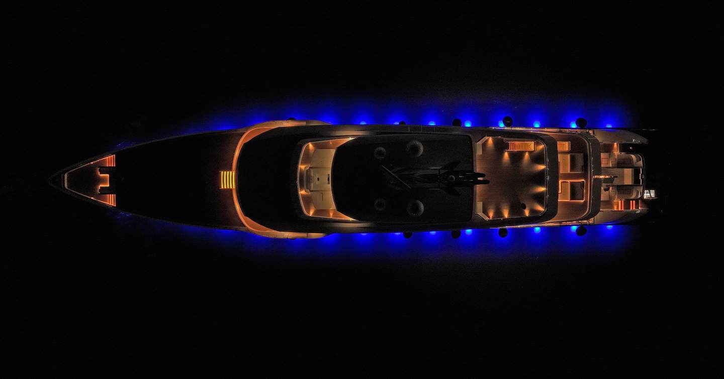 Aerial view of Superyacht Amalya at night with underwater lights