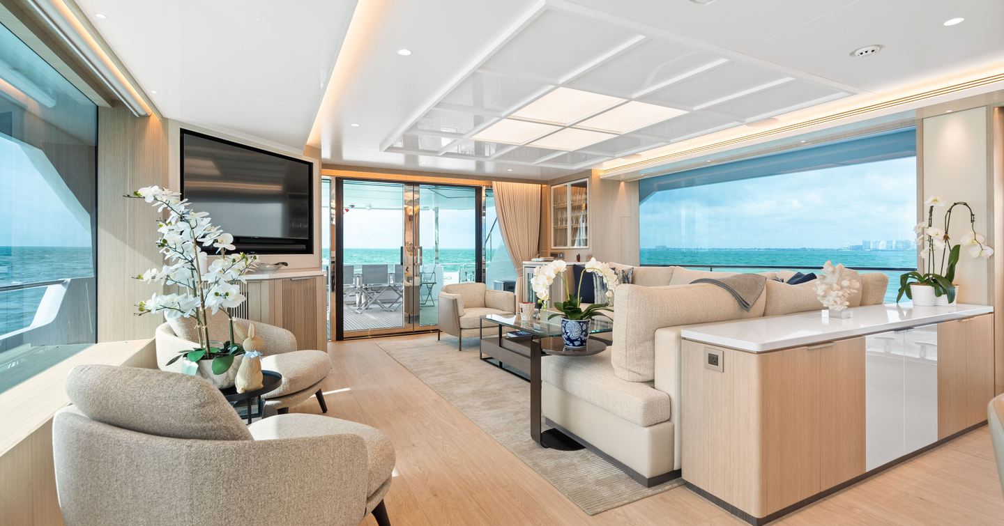 Superyacht No Regrets II's main saloon with mounted TV and L-shaped sofa