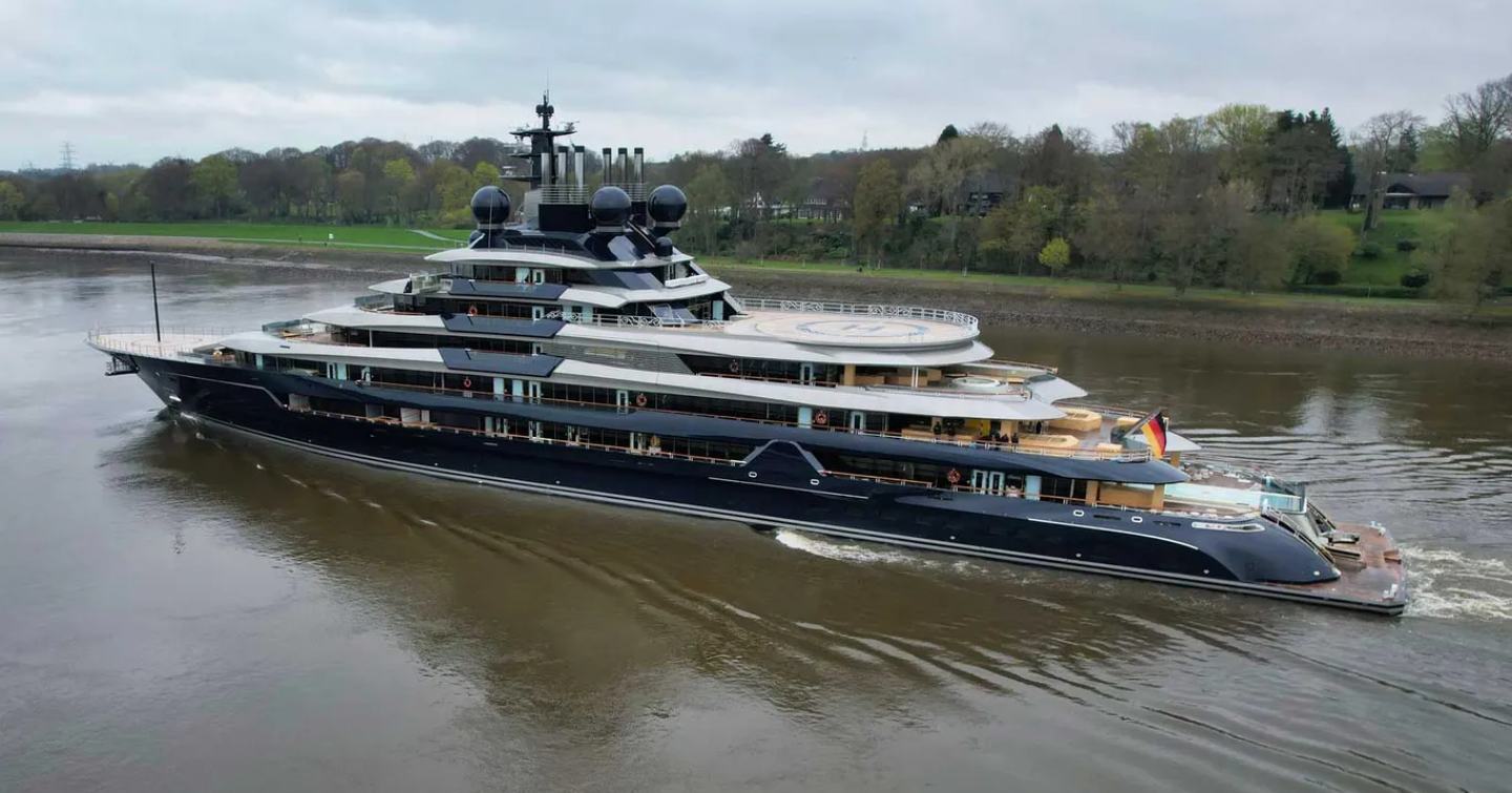 Side view of M/Y LUMINANCE underway along a German river, lots of trees are in the background.