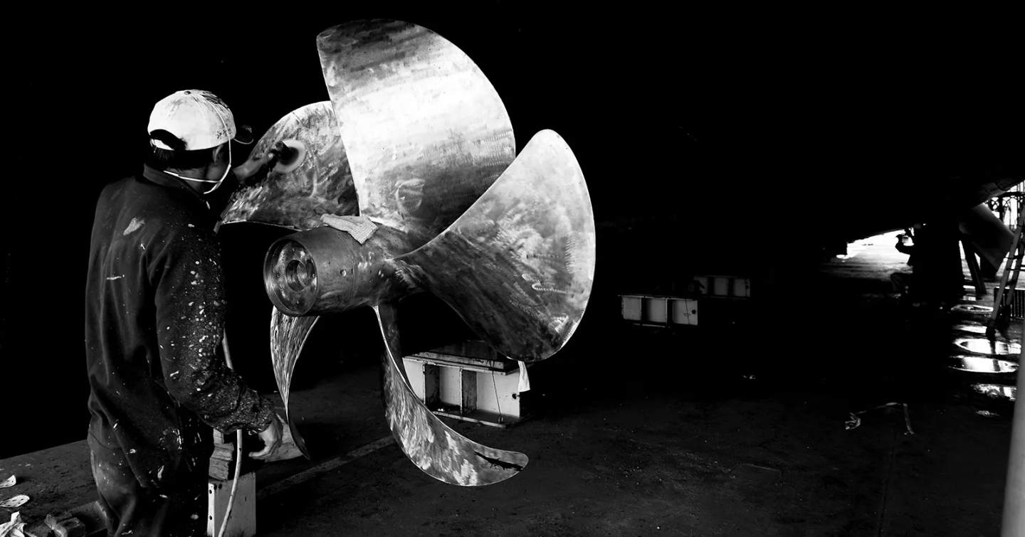 Worker next to superyacht engine propellor 