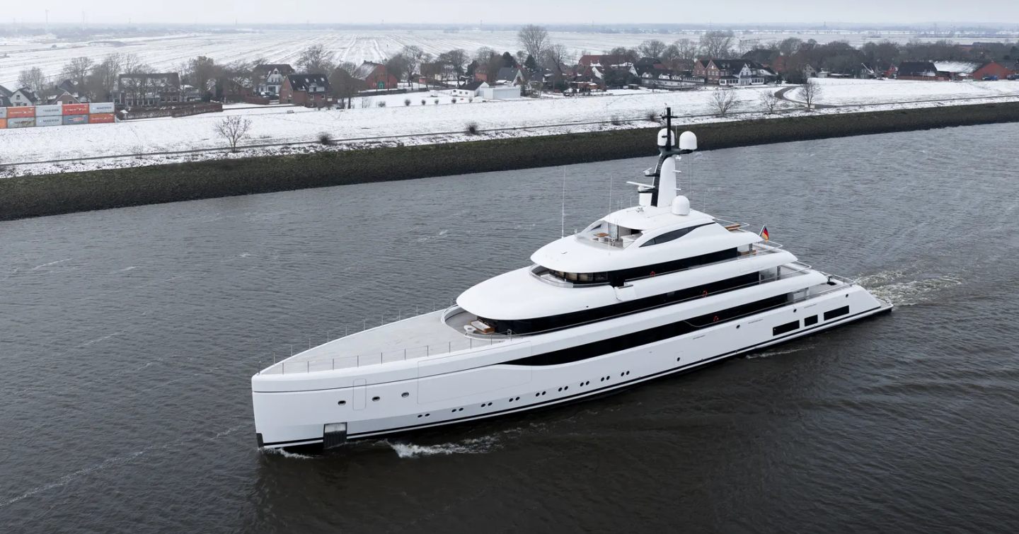 Superyacht Odisea under way next to snowy fields 