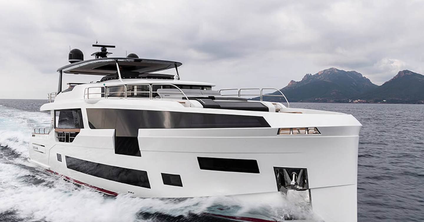 Sirena Yachts 88 underway, surrounded by sea and elevated terrain in background