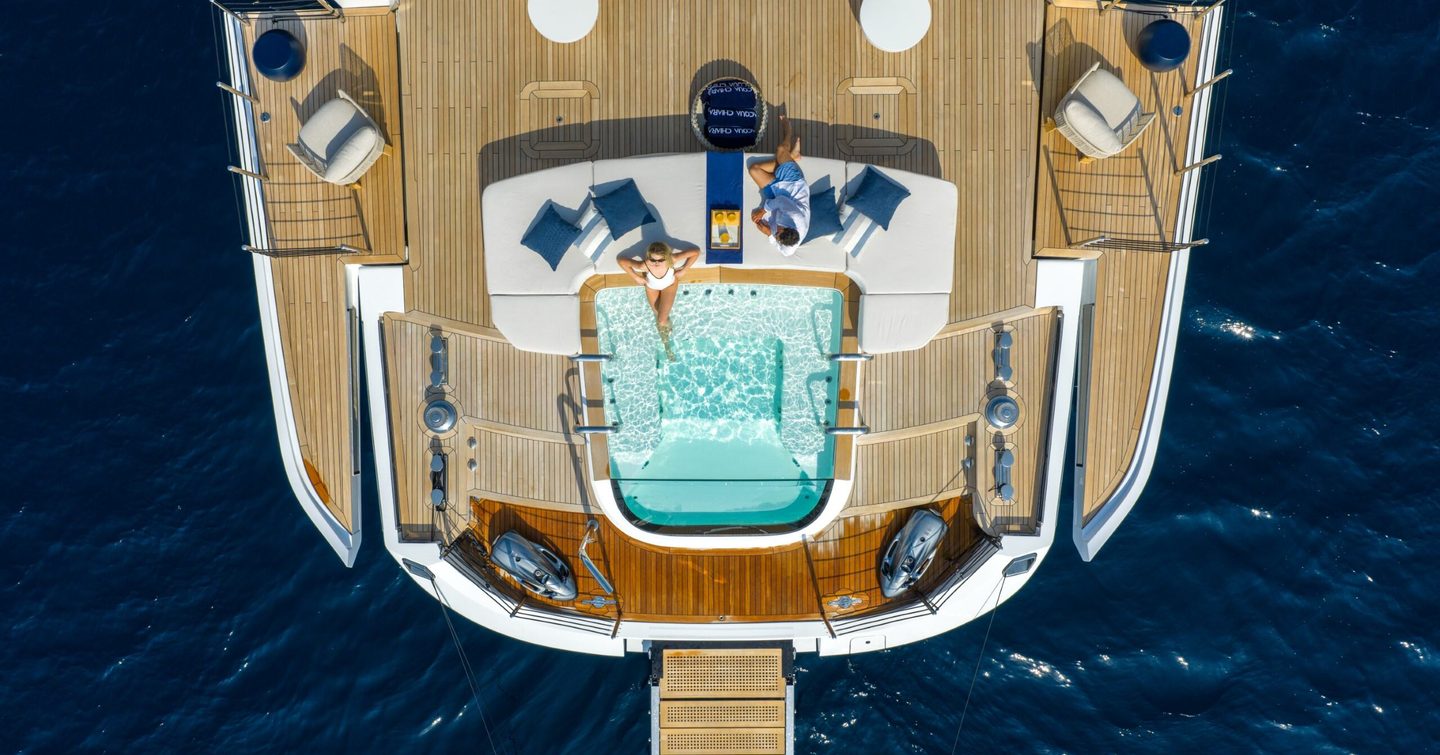 Aerial view of Superyacht Acqua Chiara infinity pool with woman lying on the edge