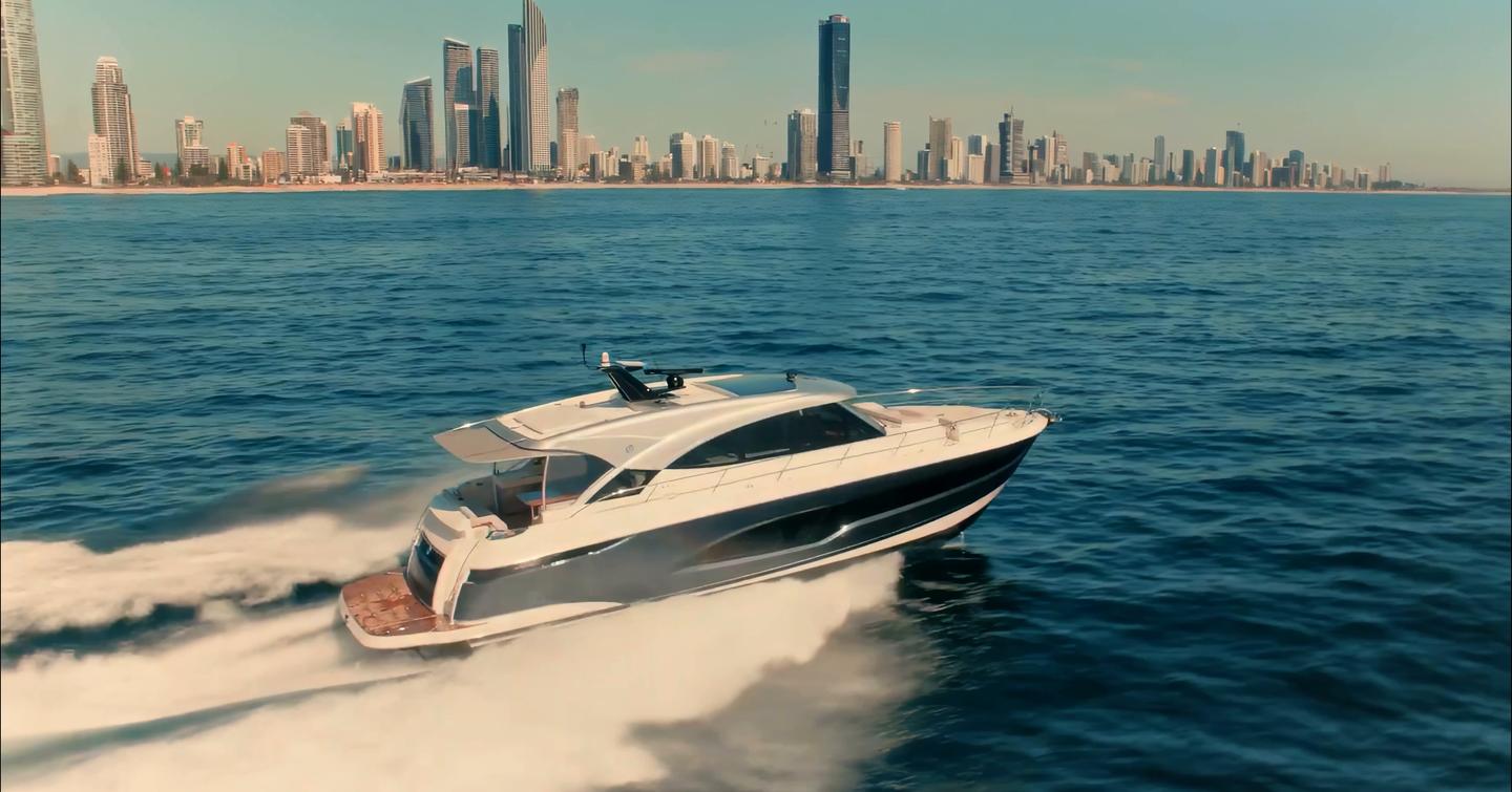 Riviera 5600 Sport Platinum Edition cruising offshore with Gold Coast skyline in the background