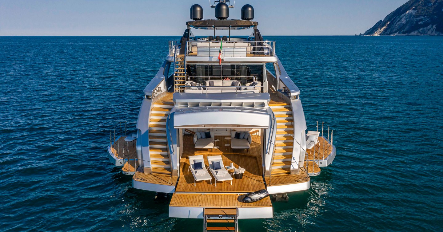 Beach Club onboard Pershing 140 'Touch Me', aft view of motor yacht, fold down balconies are on either side with sun loungers on the swim platform, surrounded by sea