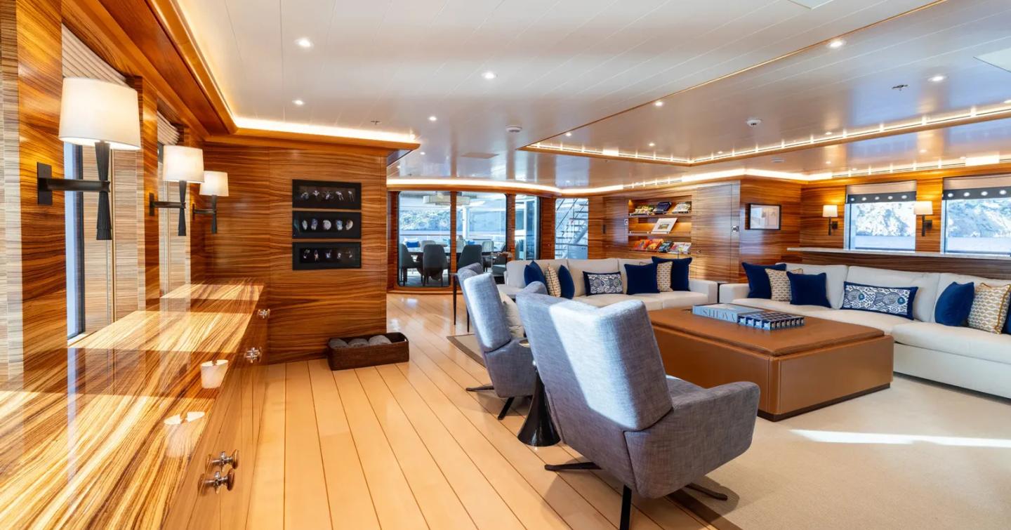 Superyacht Rocinante's saloon with white sofas and circular dining table 
