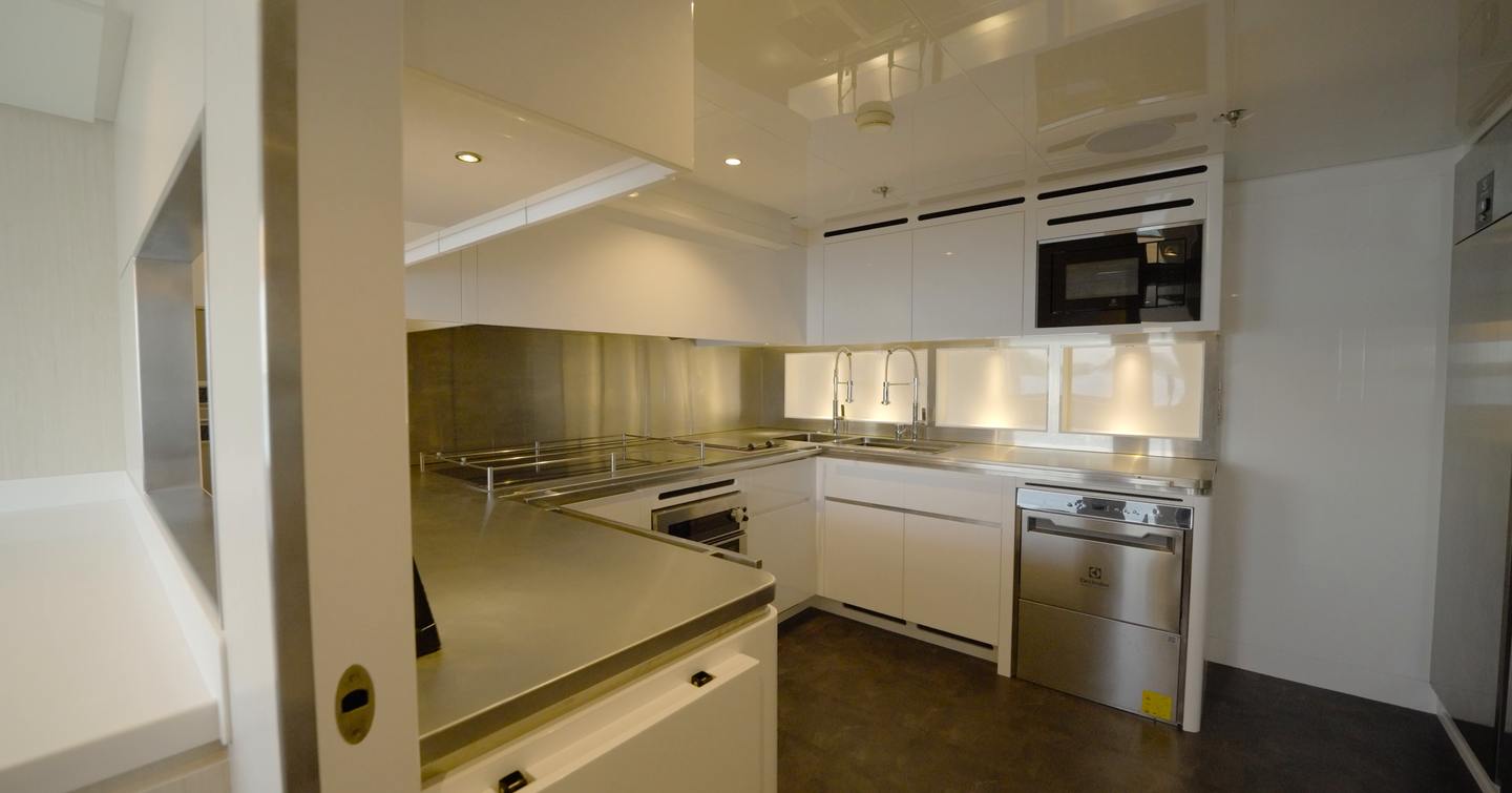 Professional galley aboard the Gulf Craft Majesty 145 with stainless steel worktops and commercial-grade appliances