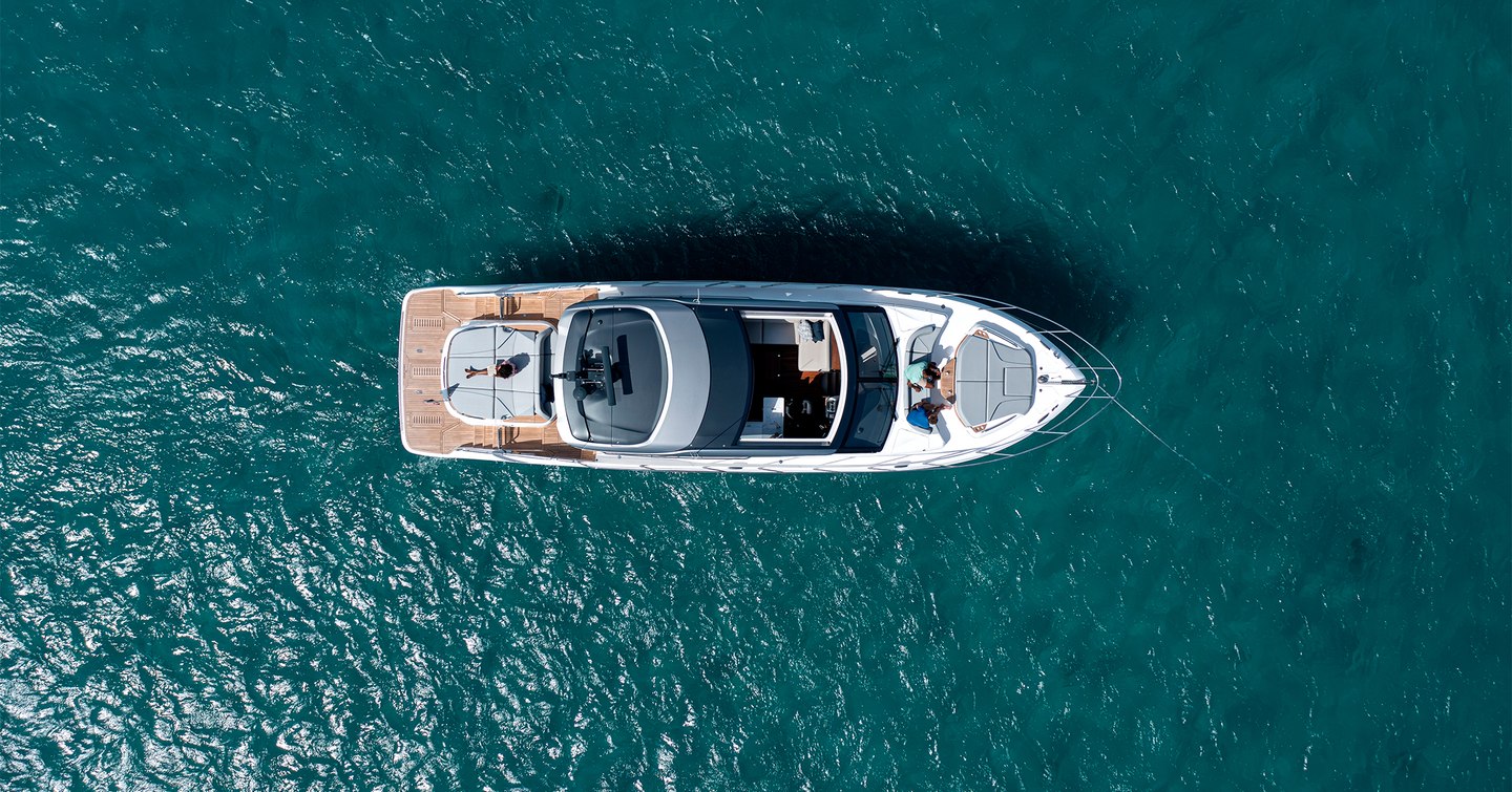 Aerial top view of Princess V55 58ft twin shaft-drive sports yacht at anchor showing foredeck sunpad and cockpit layout