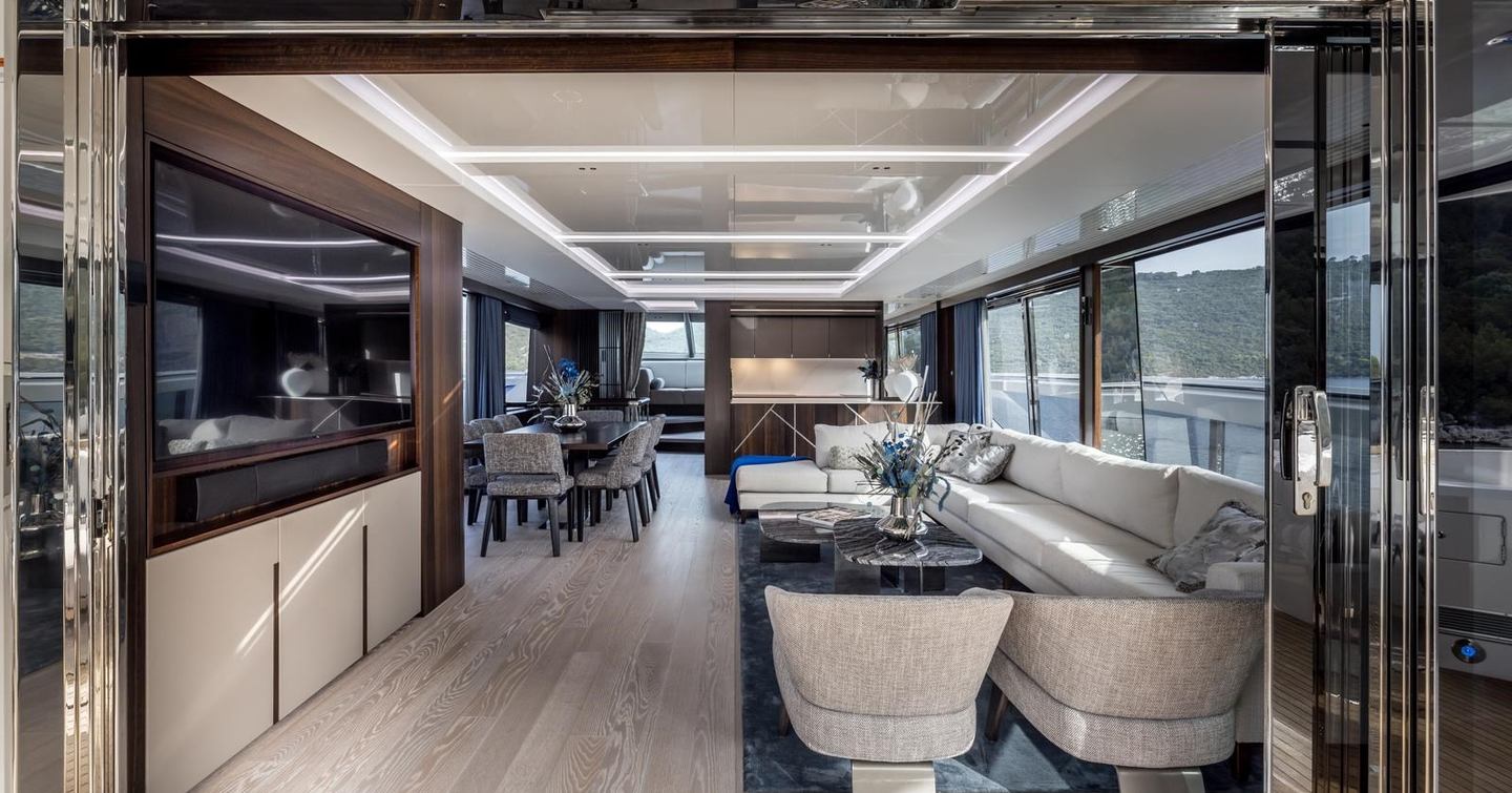 Motor yacht Exit's main saloon with L-shaped sofa and dining area