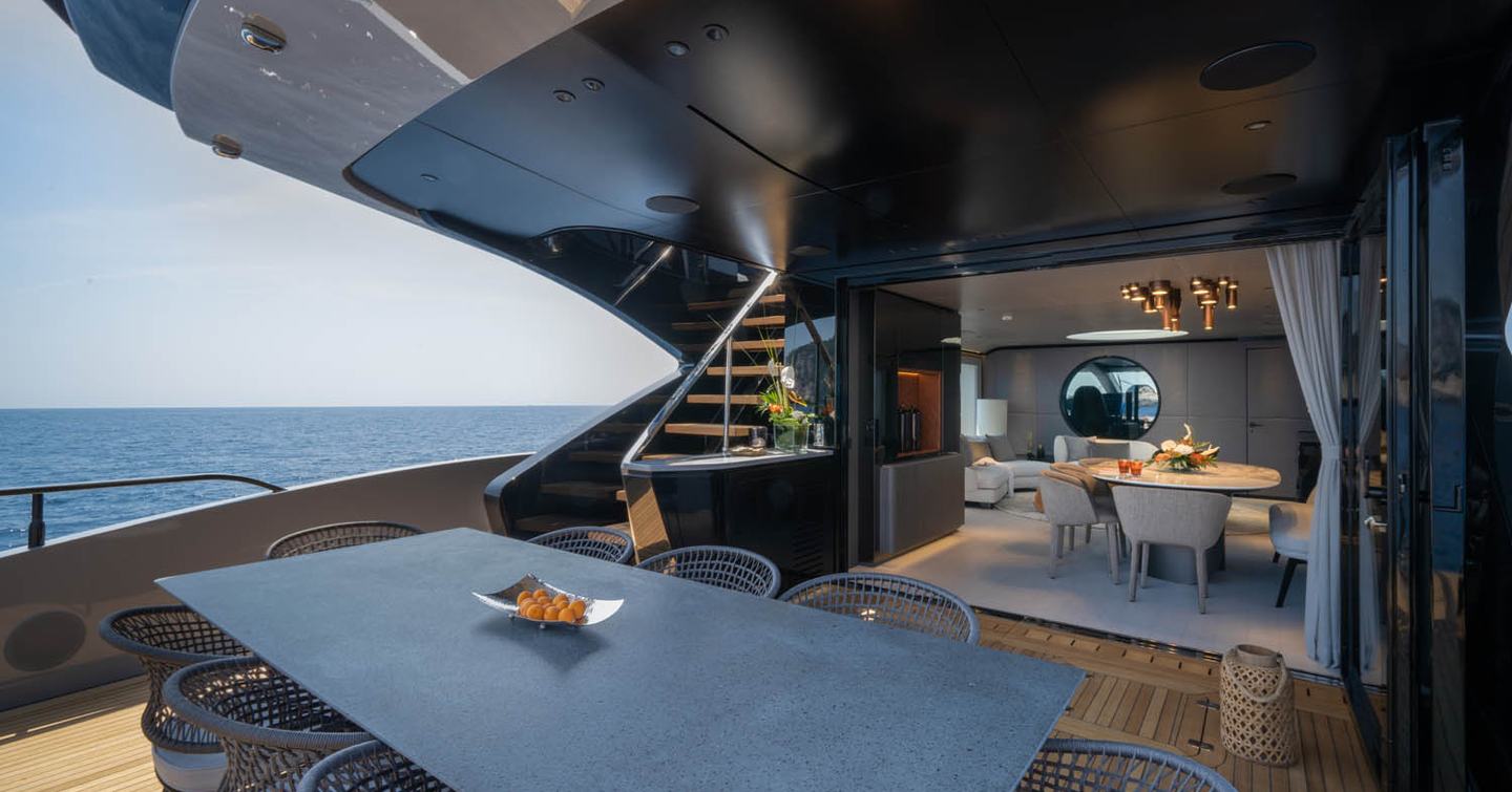 Mangusta 104 REV motor yacht aft deck with shaded alfresco dining 
