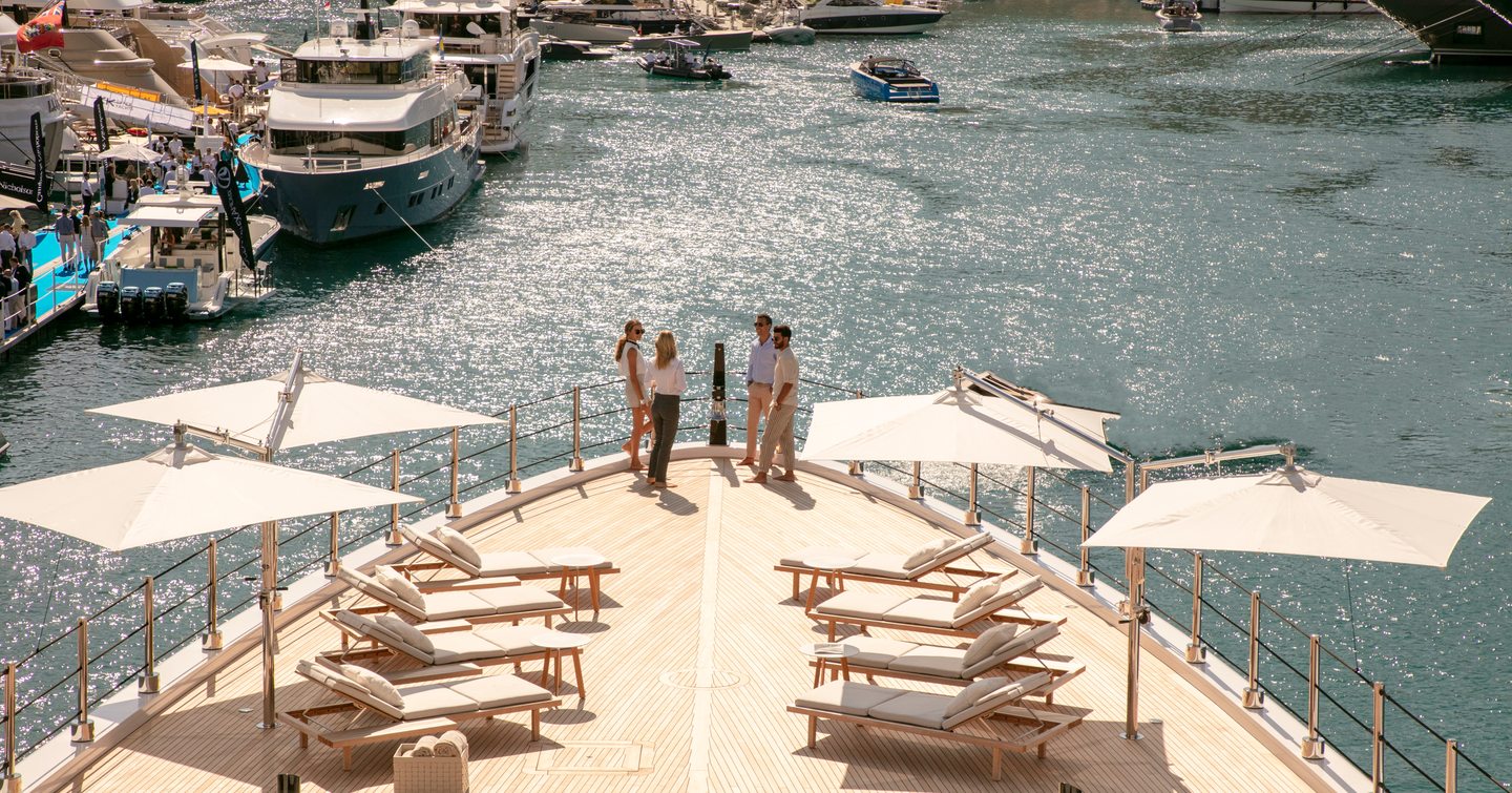 Group of people standing on the bow of a superyacht at Monaco Yacht Show.