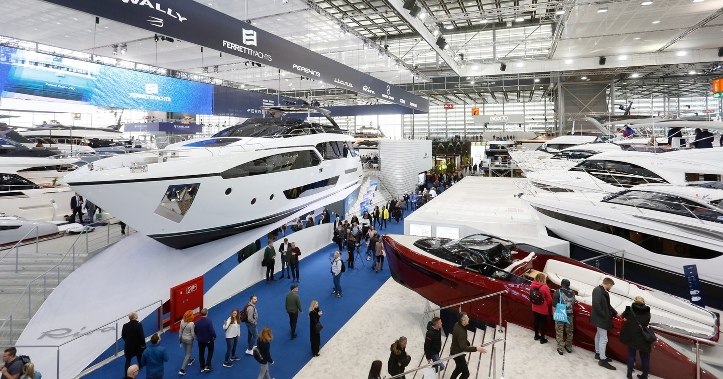 Display of superyachts during Boot Dusseldorf event, visitors walking round looking at models.