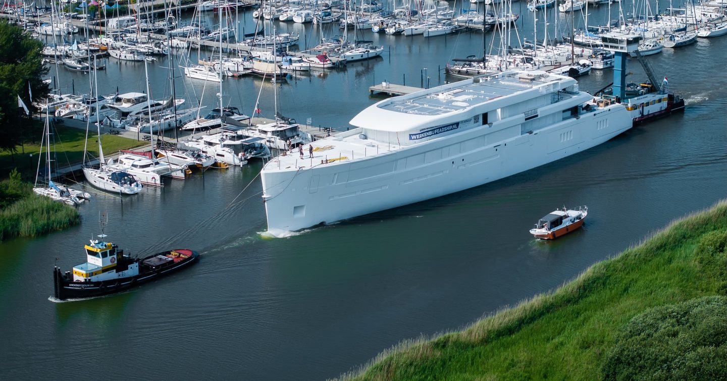 Superyacht Feadship 1015 behind tugboat pre-outfitting