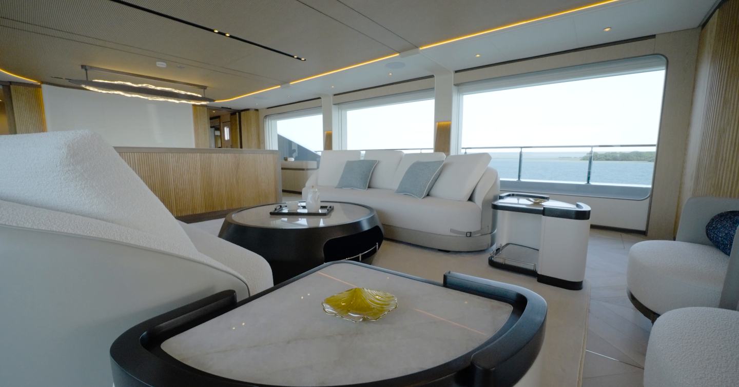Main saloon aboard the Gulf Craft Majesty 145 with curved lounge seating and side windows