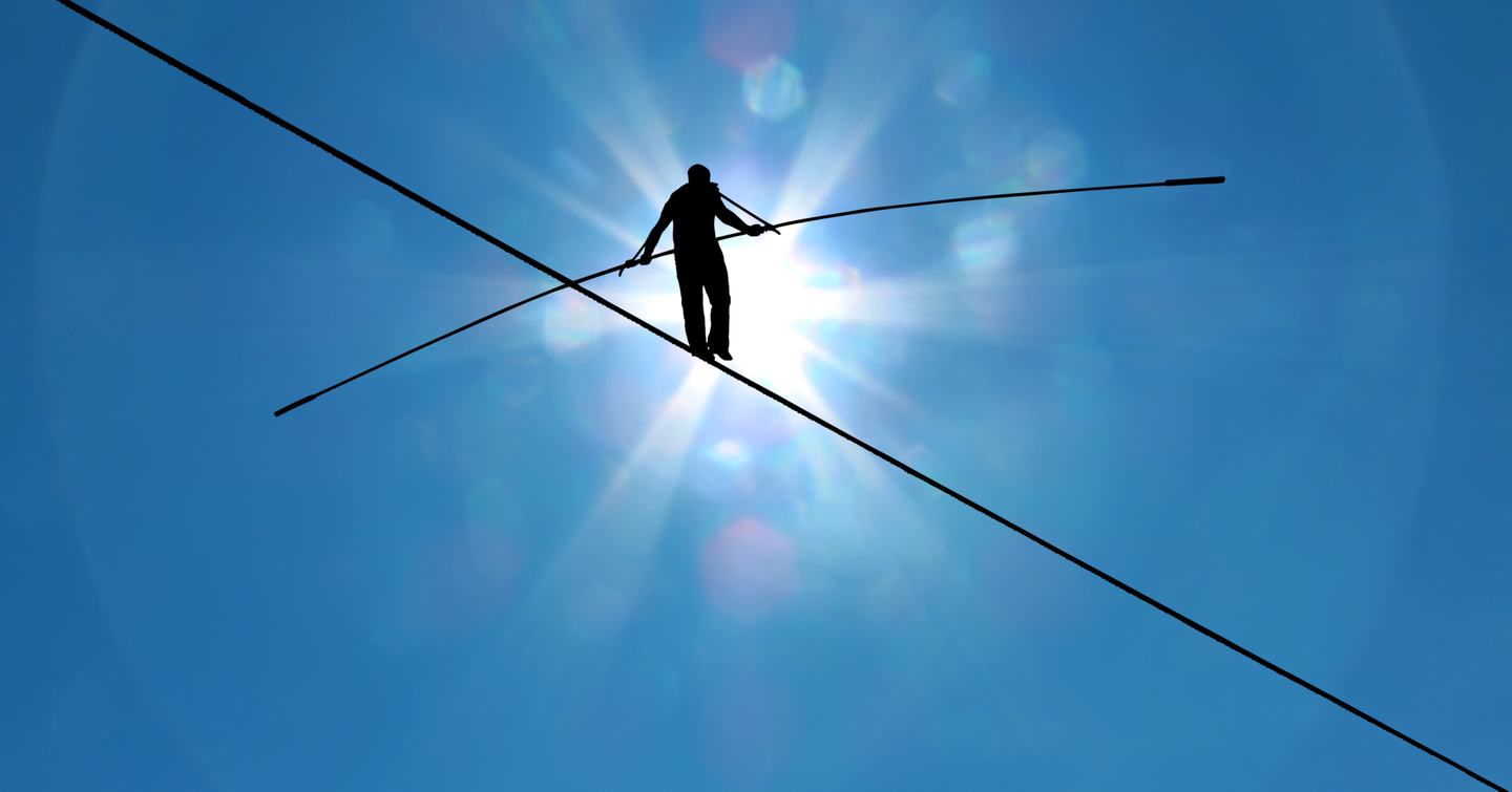 man walking high tightrope