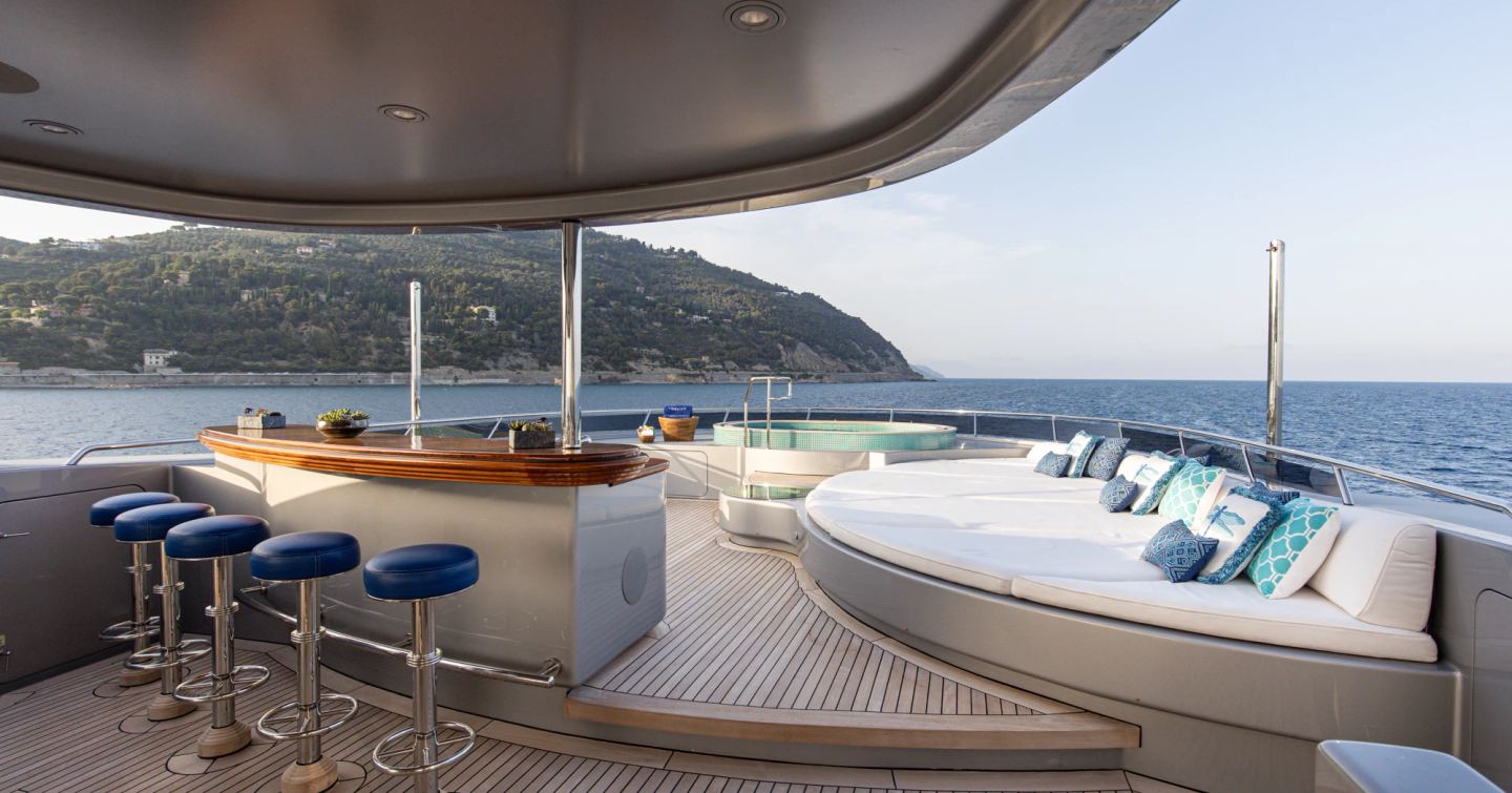 Superyacht Vibrance sundeck with shaded bar area and large white sunpad 