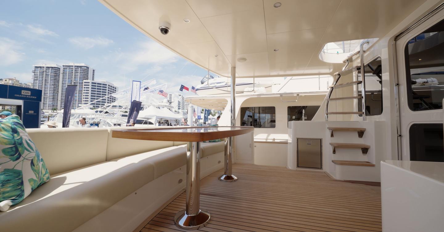 Fleming 85 shaded aft cockpit with outdoor dining area and flybridge staircase access