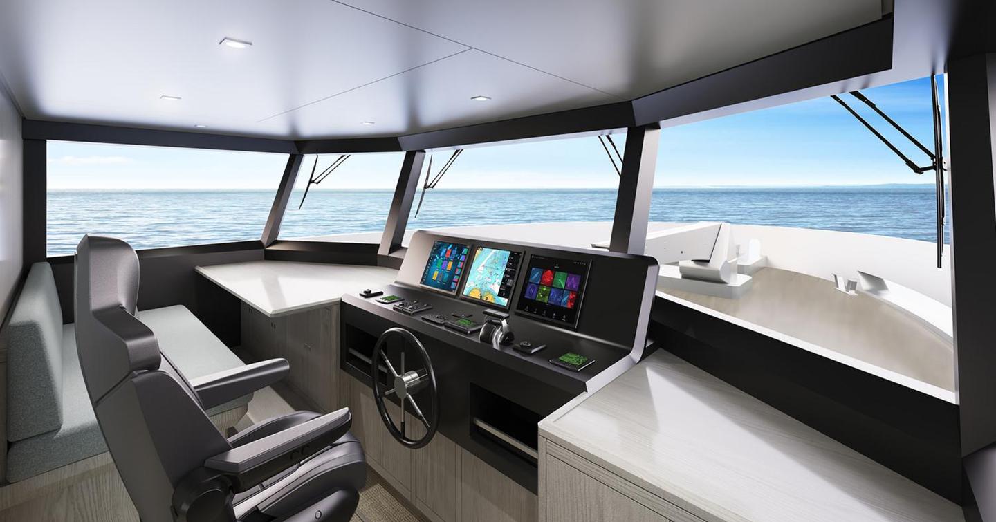 The wheelhouse aboard the Adventure 780 features a single, centered pilot seat with a central wheel and several flat screens 