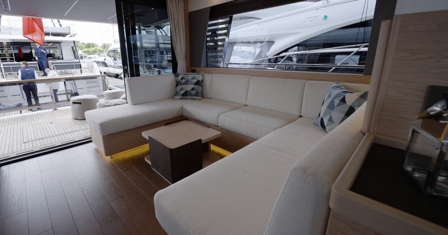 Beneteau Grand Trawler 63 saloon with U-shaped seating, panoramic glazing and aft cockpit access