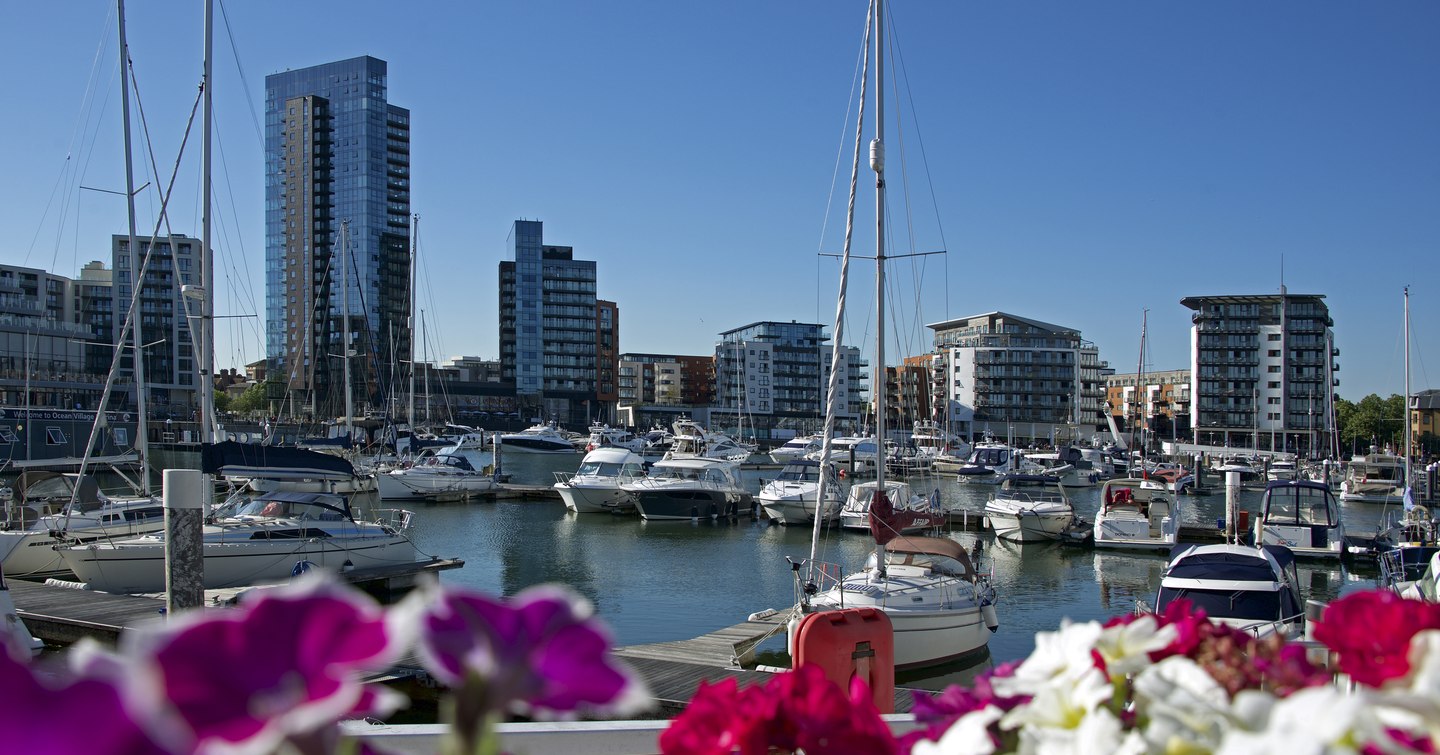 Overview of Ocean Village Marina, Southampton. Many motor yachts and sailing boats berthed in marina on a clear day.