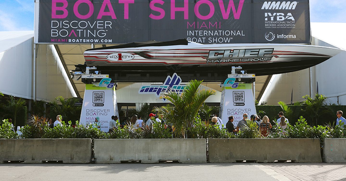 Herald Plaza in Miami during the Miami International Boat Show, speed boat on display in front of show banner.