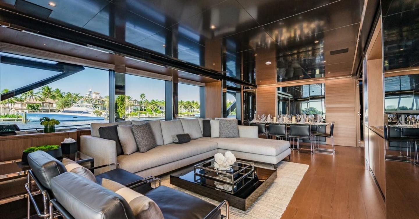 Motor yacht Beyond Beyond main saloon with L-shaped sofa and mirrored ceiling